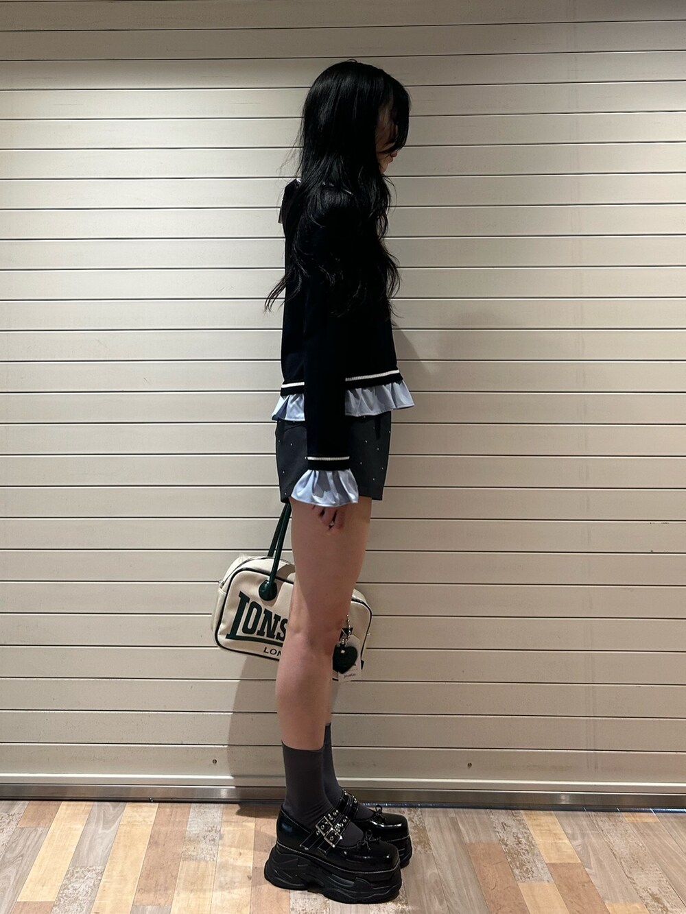 グレー系のその他パンツ、ブラック系のニット/セーター、ホワイト系のボストンバッグを着用したレディースの秋コーディネートの2枚目の写真