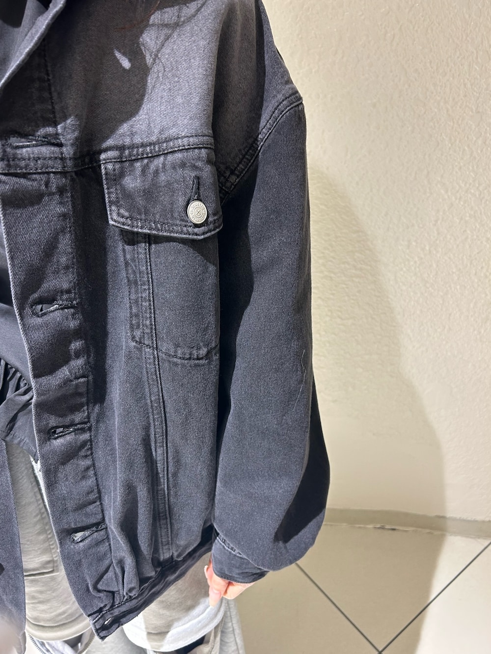 ブラック系のデニムジャケット、ブラック系のシャツ/ブラウス、グレー系のスウェットパンツを着用したレディースの春コーディネートの4枚目の写真