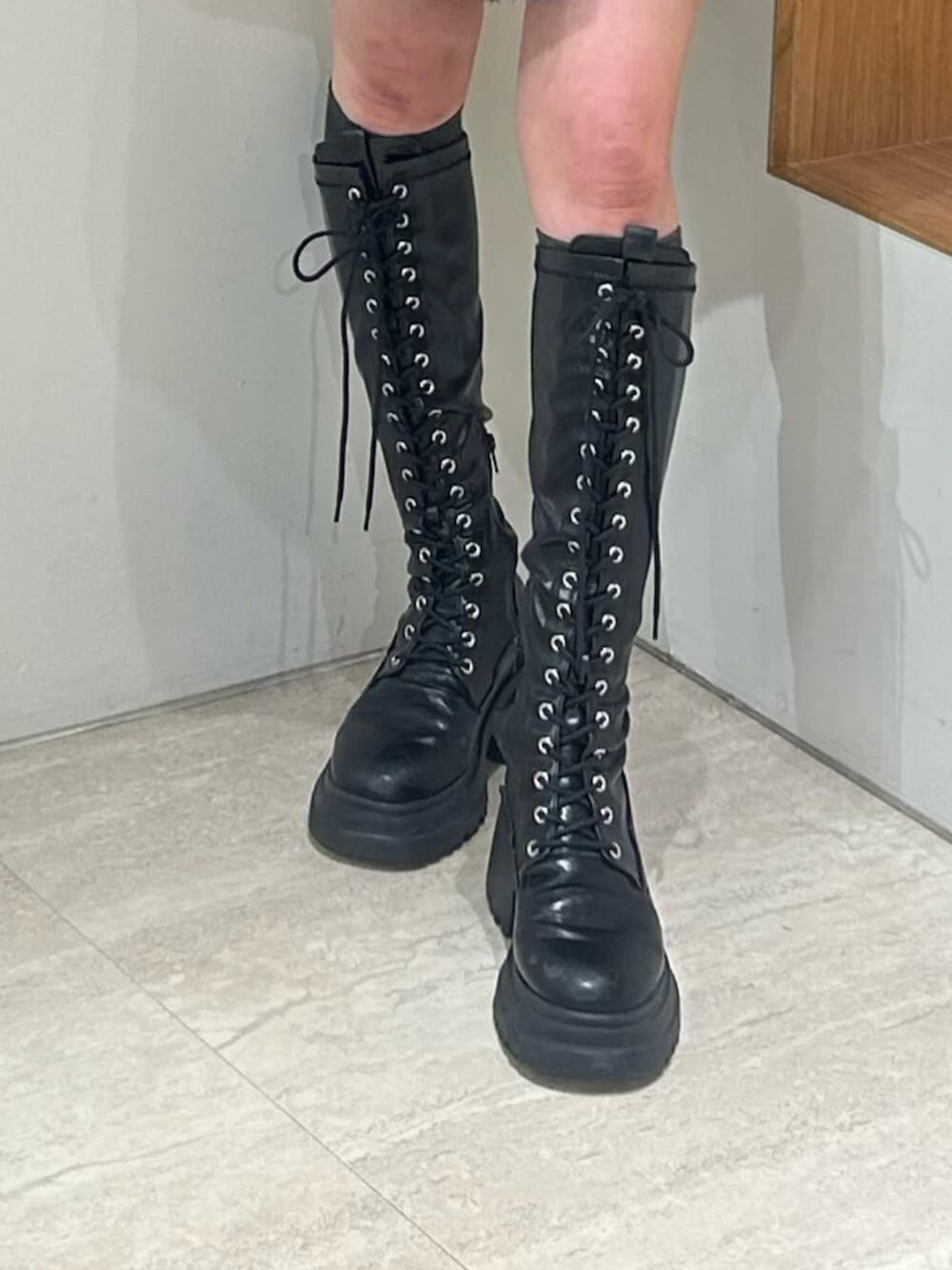 ブラック系のブーツ、ブラック系のニット/セーター、ブルー系のスカートを着用したレディースの秋コーディネートの6枚目の写真