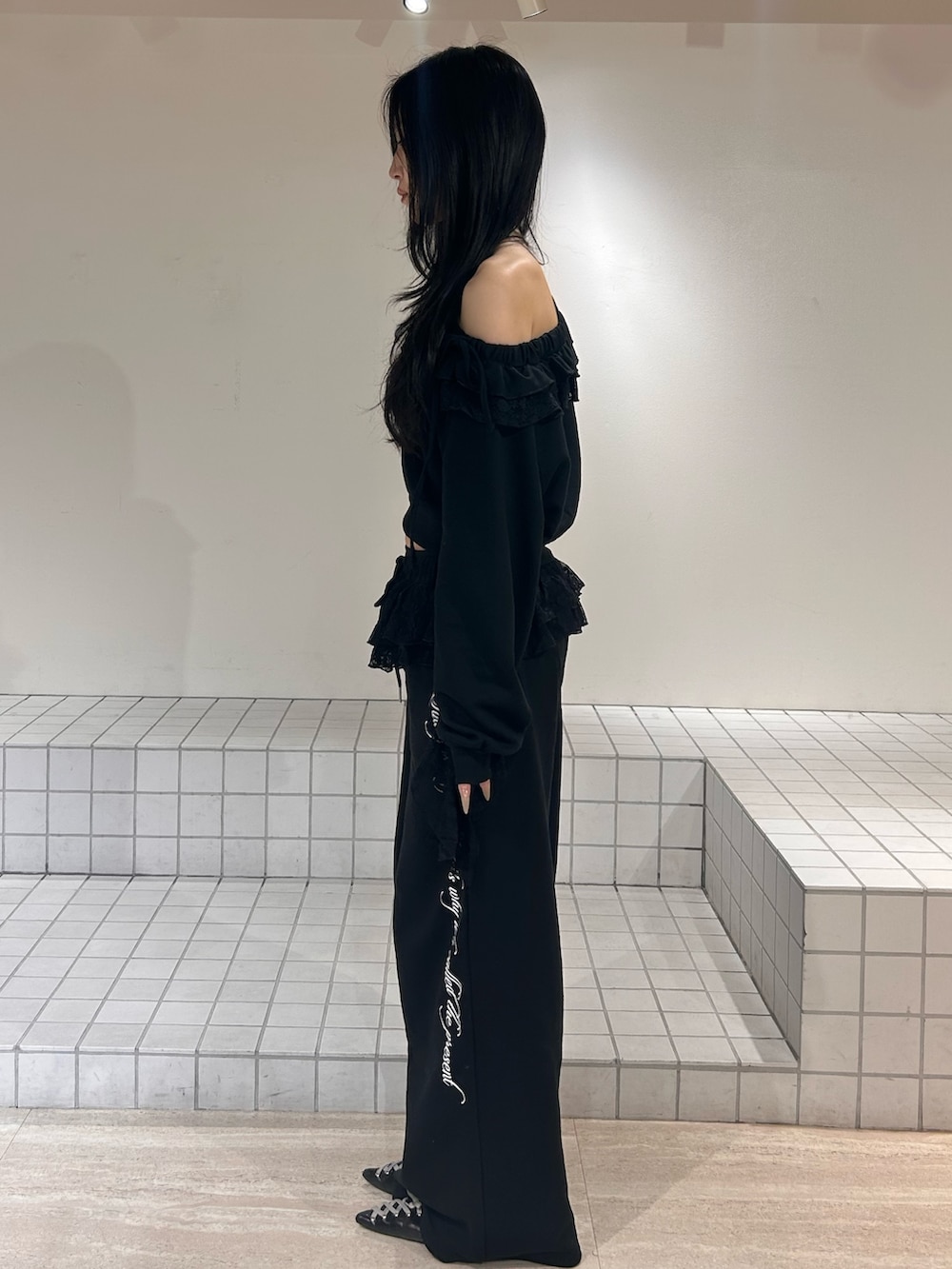 ブラック系のスウェット、ブラック系のスウェットパンツ、ブラック系のパンプスを着用したレディースの冬コーディネートの2枚目の写真