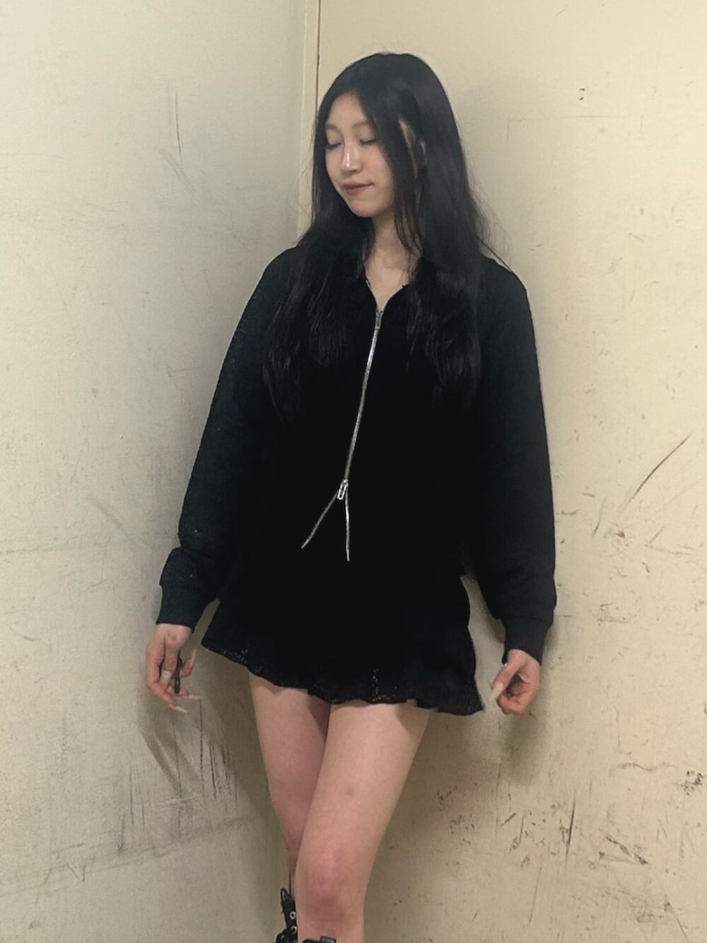 ブラック系のブーツ、ブラック系のスカート、ブラック系のパーカーを着用したレディースの春コーディネートの4枚目の写真