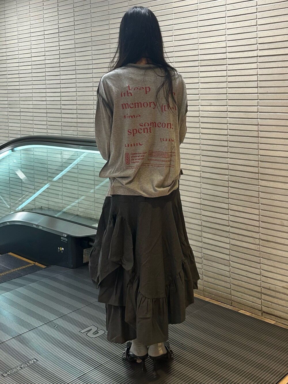 グレー系のTシャツ/カットソー、グレー系のスカート、ブラック系のパンプスを着用したレディースの夏コーディネートの3枚目の写真