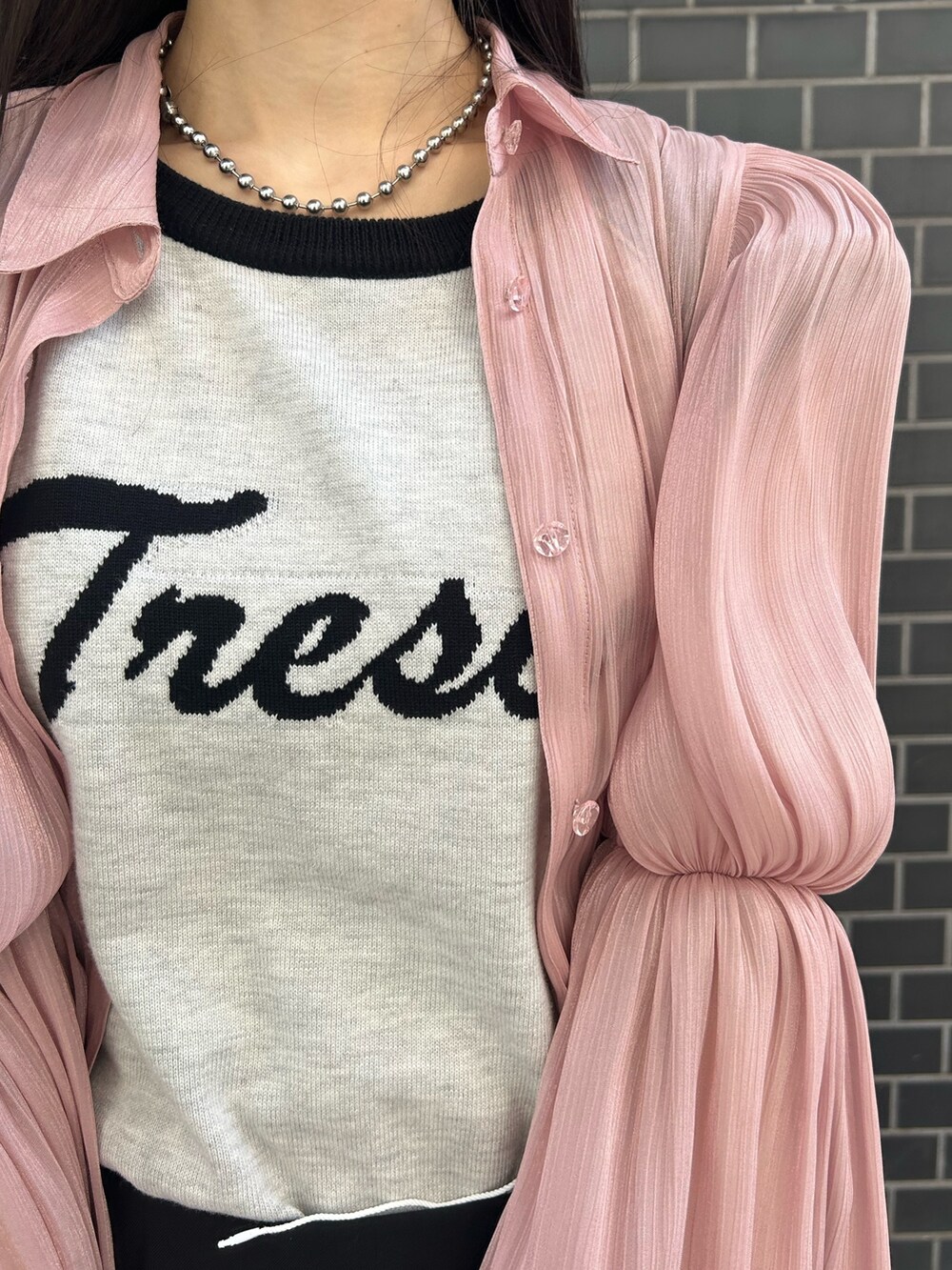 ピンク系のシャツ/ブラウス、ホワイト系のニット/セーター、ブラック系のスカートを着用したレディースの春コーディネートの5枚目の写真