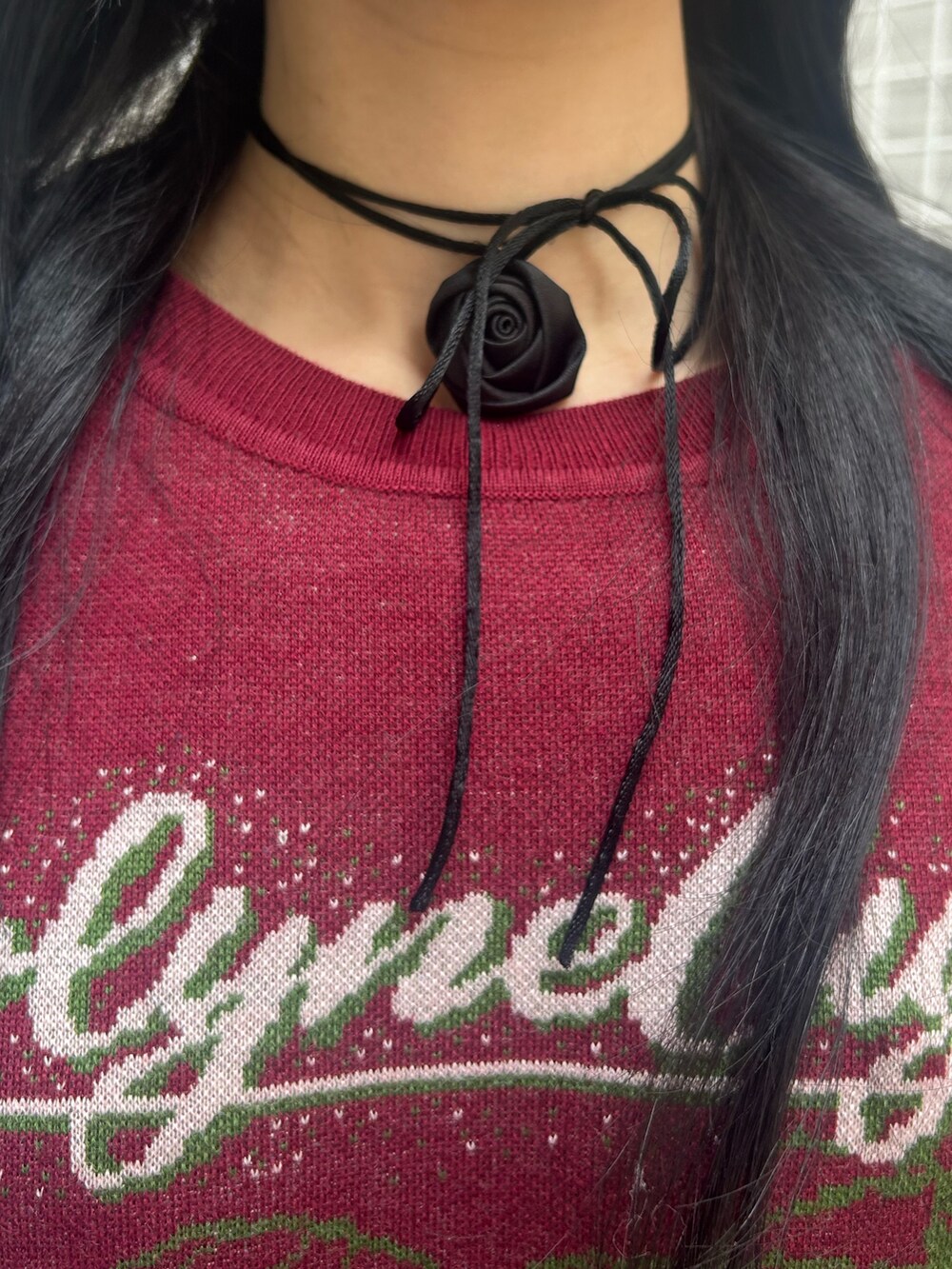 レッド系のニット/セーター、ブラック系のスカート、ブラック系のチョーカーを着用したレディースの秋コーディネートの5枚目の写真