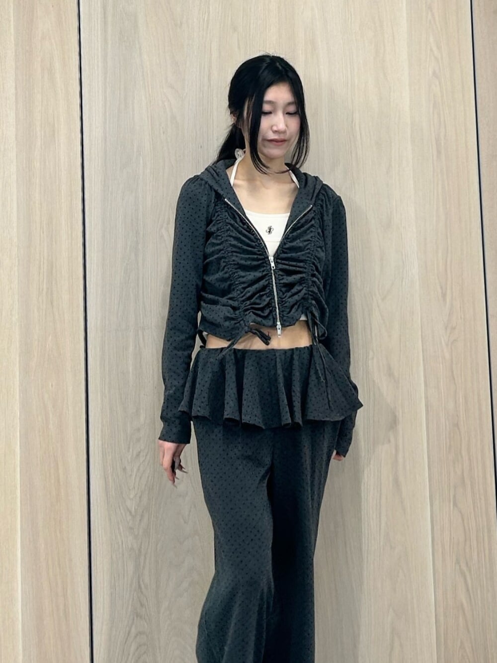 ブラック系のパンプス、ホワイト系のキャミソール、グレー系のスウェットパンツを着用したレディースの春コーディネートの4枚目の写真