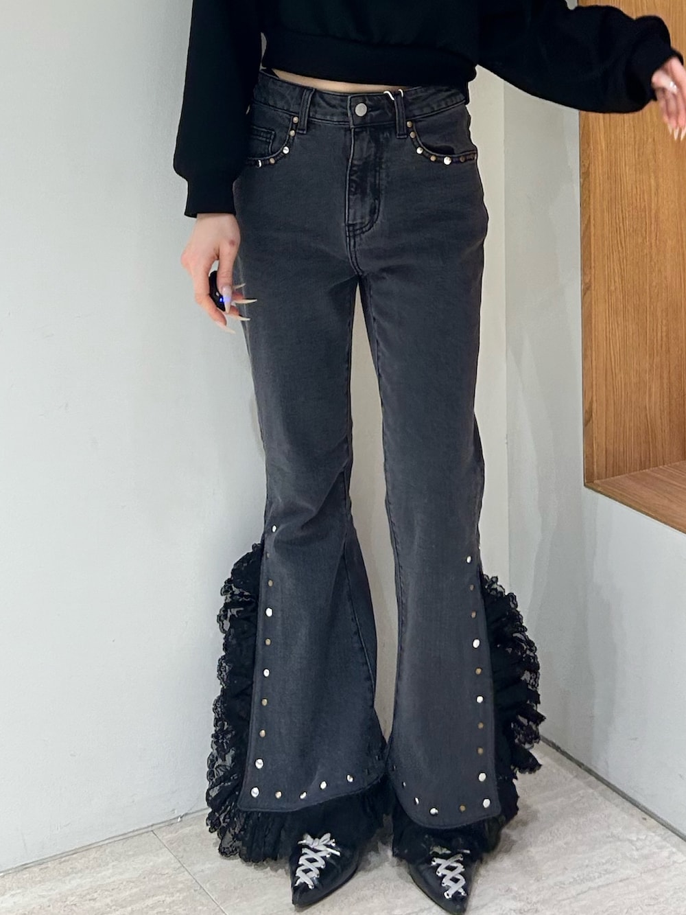 ブラック系のスウェット、ブラック系のデニムパンツ、ブラック系のパンプスを着用したレディースの冬コーディネートの6枚目の写真