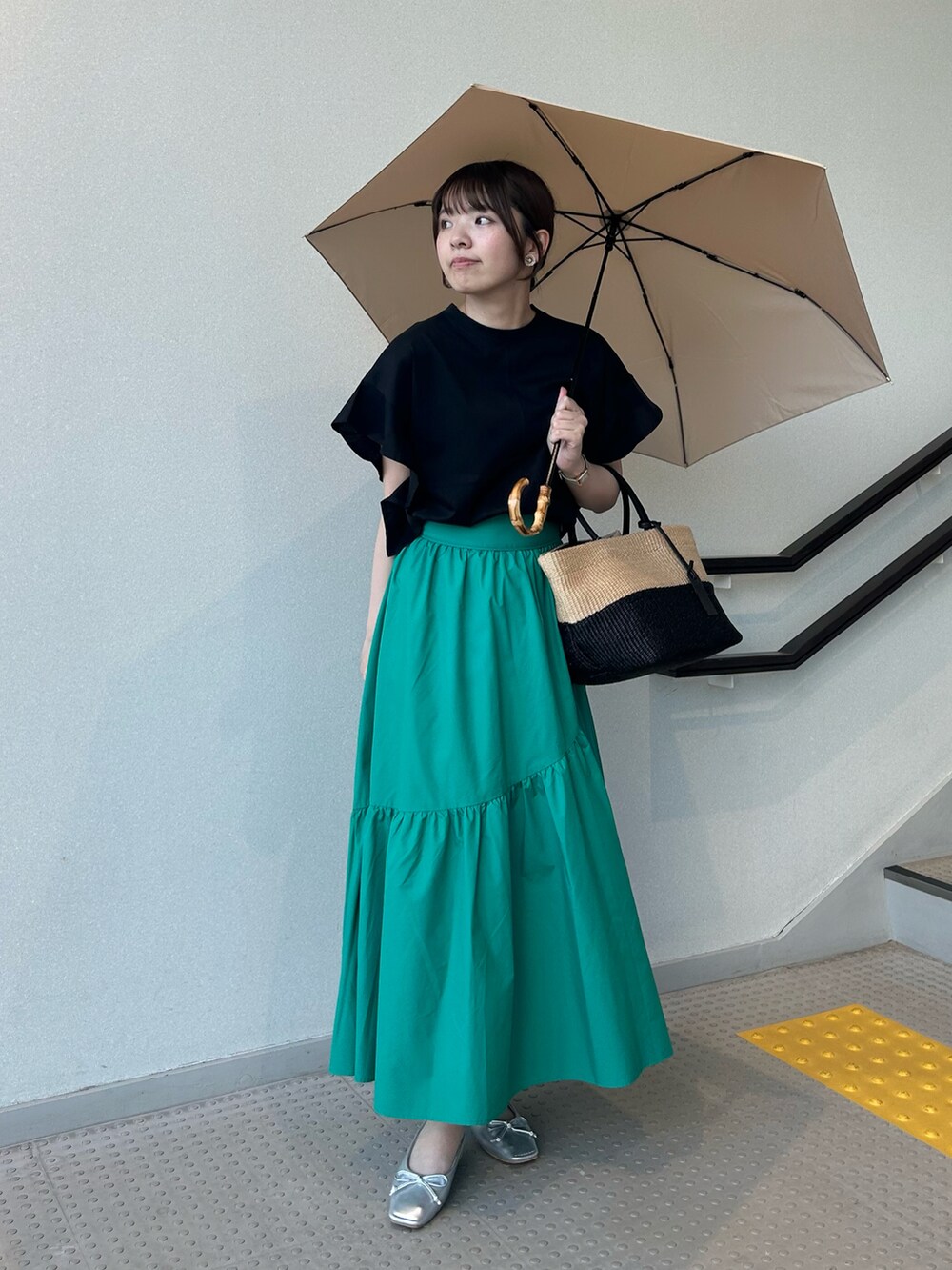 ブラック系のTシャツ/カットソー、グリーン系のスカート、シルバー系のバレエシューズを着用したレディースの夏コーディネートの2枚目の写真