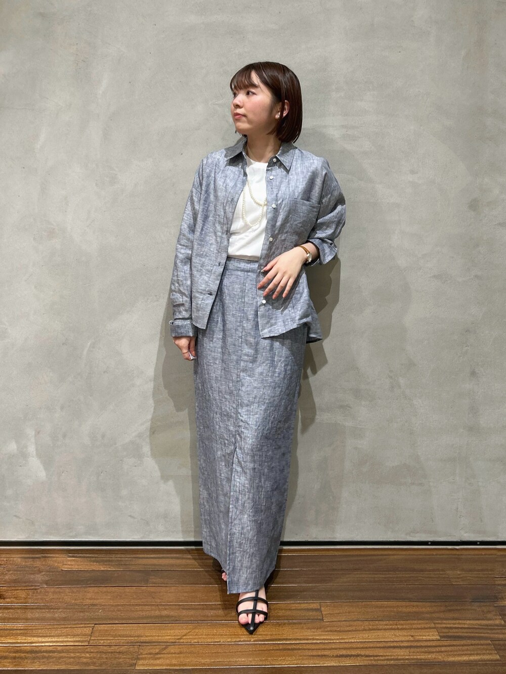 ブルー系のシャツ/ブラウス、ブルー系のスカート、ブラック系のサンダルを着用したレディースの夏コーディネートの2枚目の写真