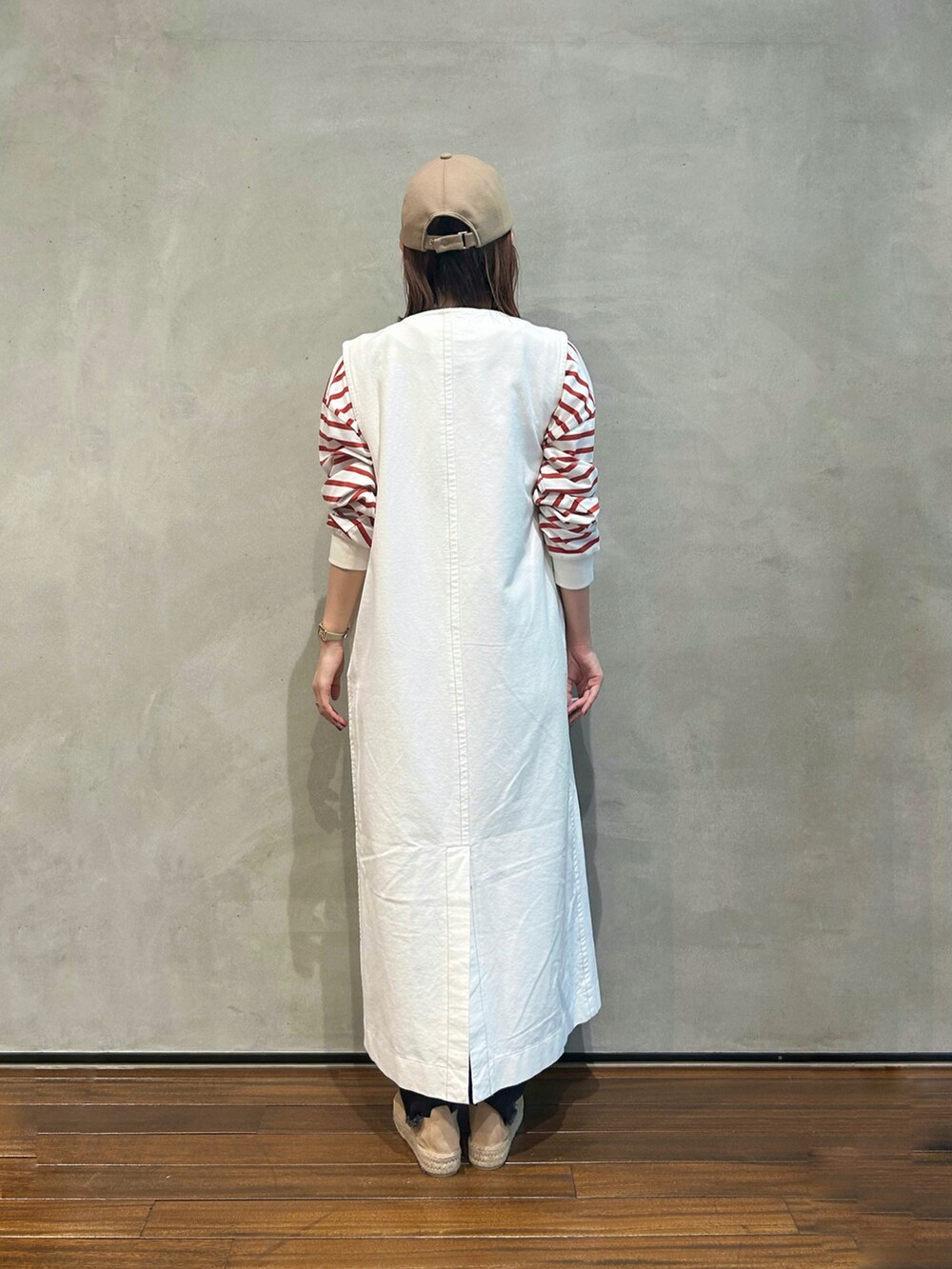 レッド系のTシャツ/カットソー、ホワイト系のワンピース、ブラック系のデニムパンツを着用したレディースの秋コーディネートの3枚目の写真