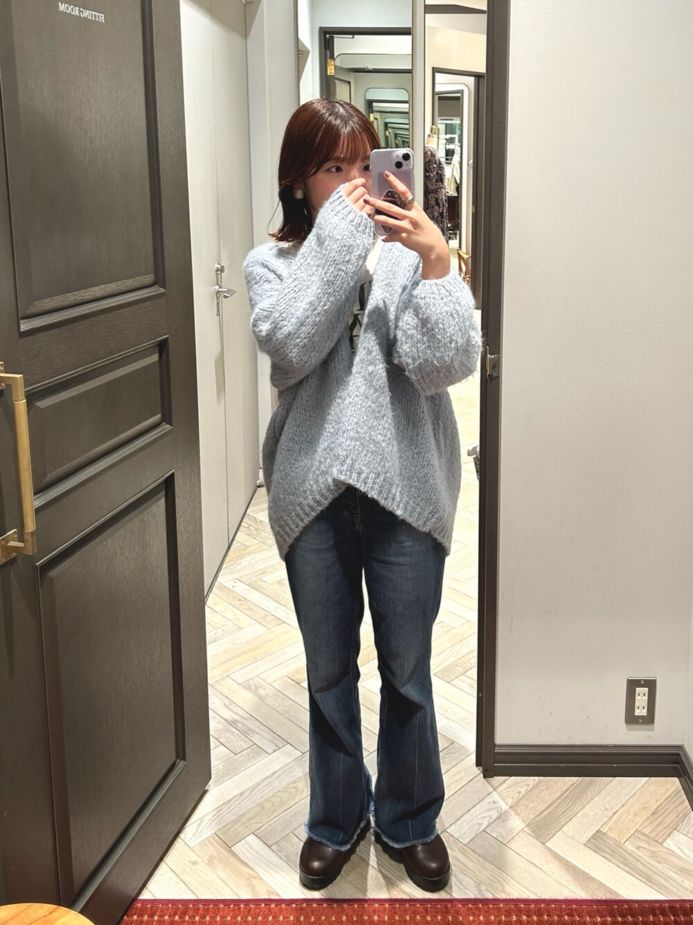 ブラウン系のブーツ、ブルー系のデニムパンツ、ブルー系のカーディガン/ボレロを着用したレディースの秋コーディネートの2枚目の写真