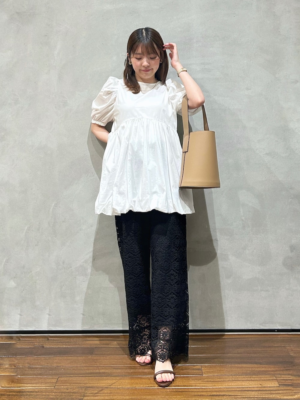 ホワイト系のシャツ/ブラウス、ブラック系のその他パンツ、ブラウン系のトートバッグを着用したレディースの夏コーディネートの2枚目の写真