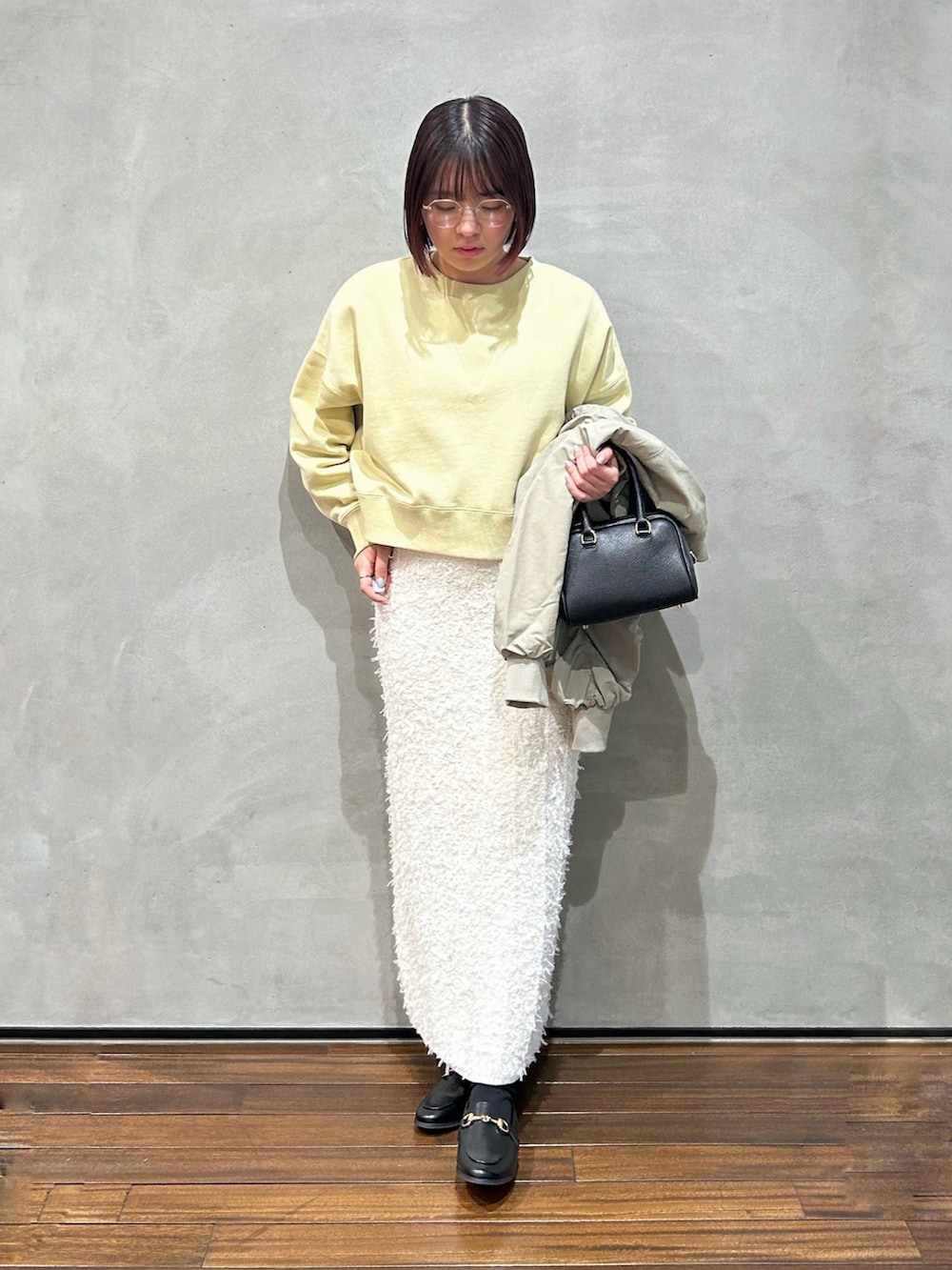 イエロー系のスウェット、グレー系のブルゾン、ブラック系のショルダーバッグを着用したレディースの春コーディネートの2枚目の写真