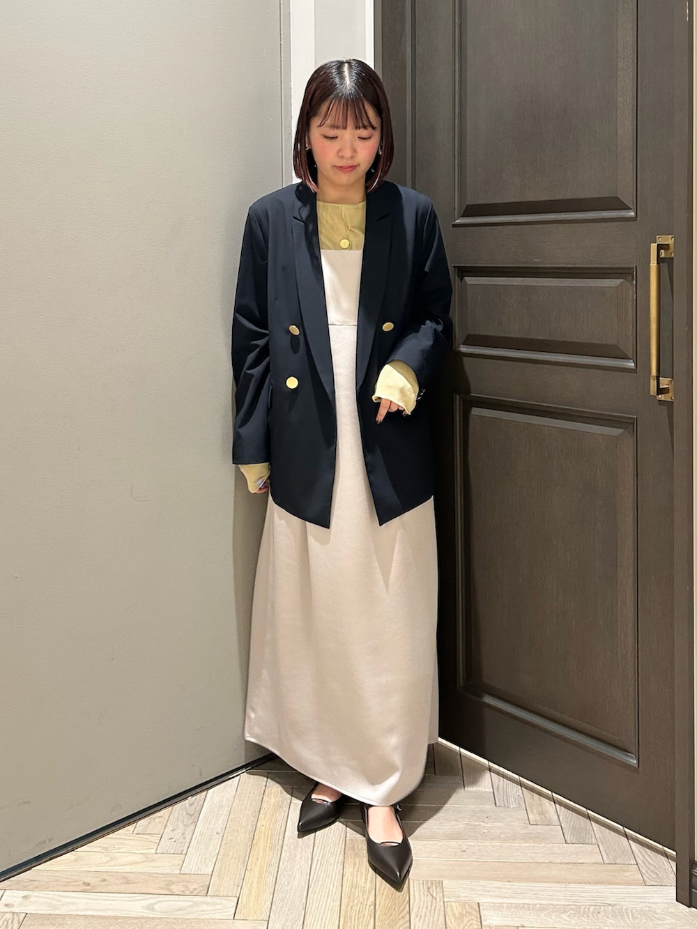 ブルー系のテーラードジャケット、グレー系のワンピース、イエロー系のTシャツ/カットソーを着用したレディースの春コーディネートの2枚目の写真