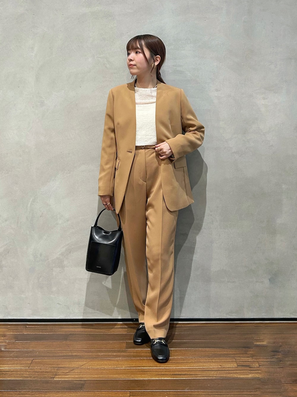 イエロー系のノーカラージャケット、イエロー系のその他パンツ、ブラック系のショルダーバッグを着用したレディースの秋コーディネートの2枚目の写真