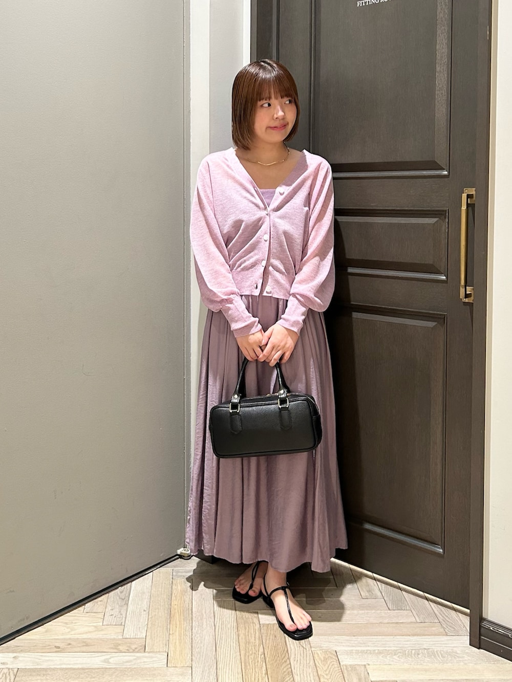 パープル系のワンピース、パープル系のカーディガン/ボレロ、ブラック系のサンダルを着用したレディースの夏コーディネートの2枚目の写真