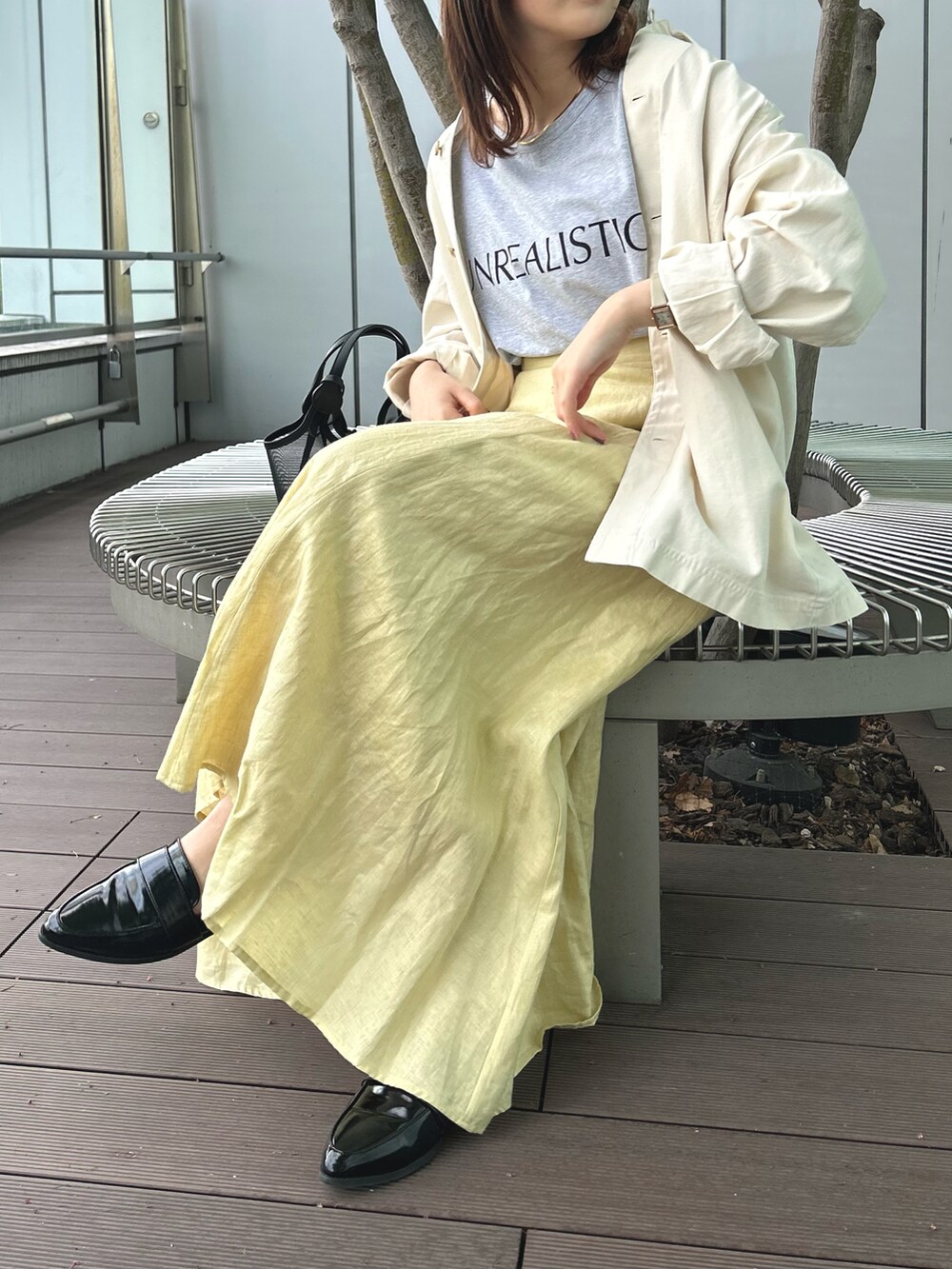 グレー系のTシャツ/カットソー、ベージュ系のシャツ/ブラウス、イエロー系のスカートを着用したレディースの春コーディネートの3枚目の写真