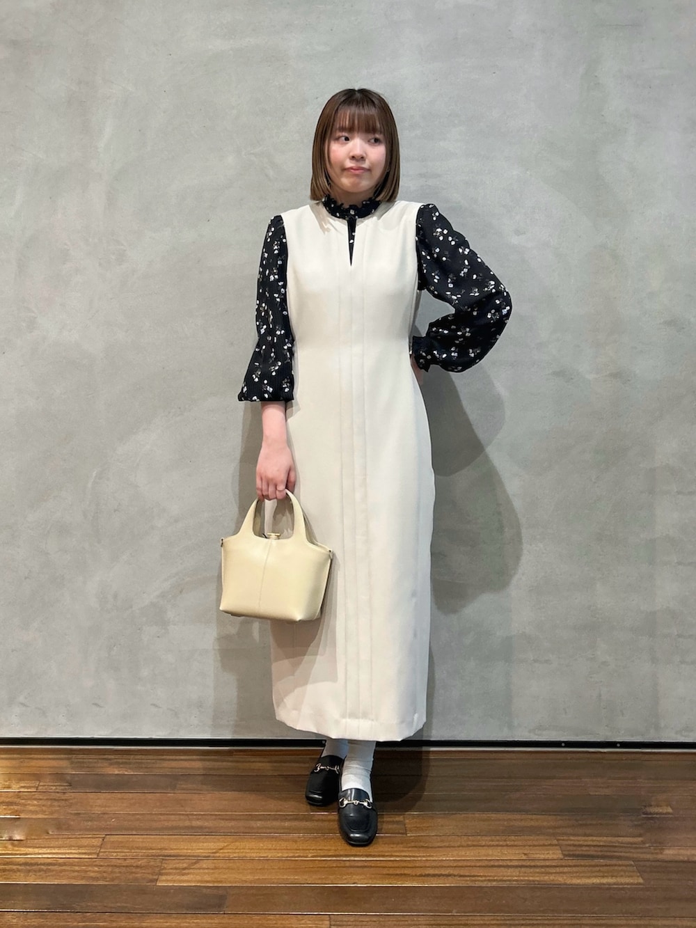ベージュ系のワンピース、ブラック系のシャツ/ブラウス、ブラック系のローファーを着用したレディースの夏コーディネートの2枚目の写真