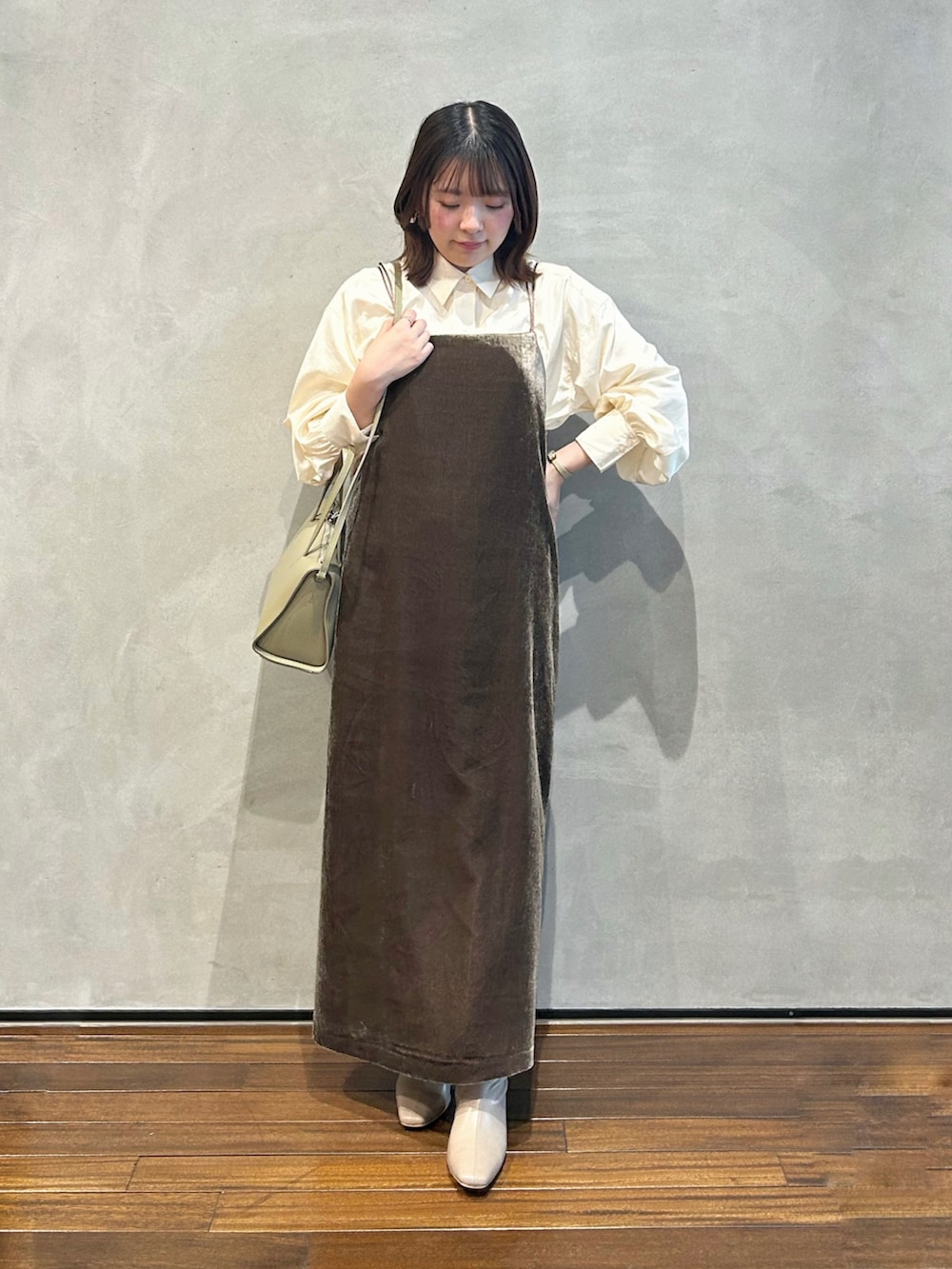 ブラウン系のワンピース、ベージュ系のシャツ/ブラウス、ベージュ系のブーツを着用したレディースの冬コーディネートの2枚目の写真