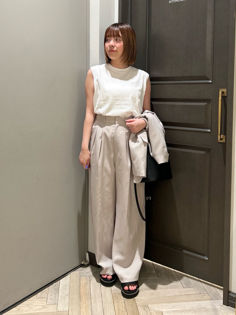ベージュ系のその他パンツ、ブラック系のショルダーバッグ、ブラック系のサンダルを着用したレディースの夏コーディネートの2枚目の写真