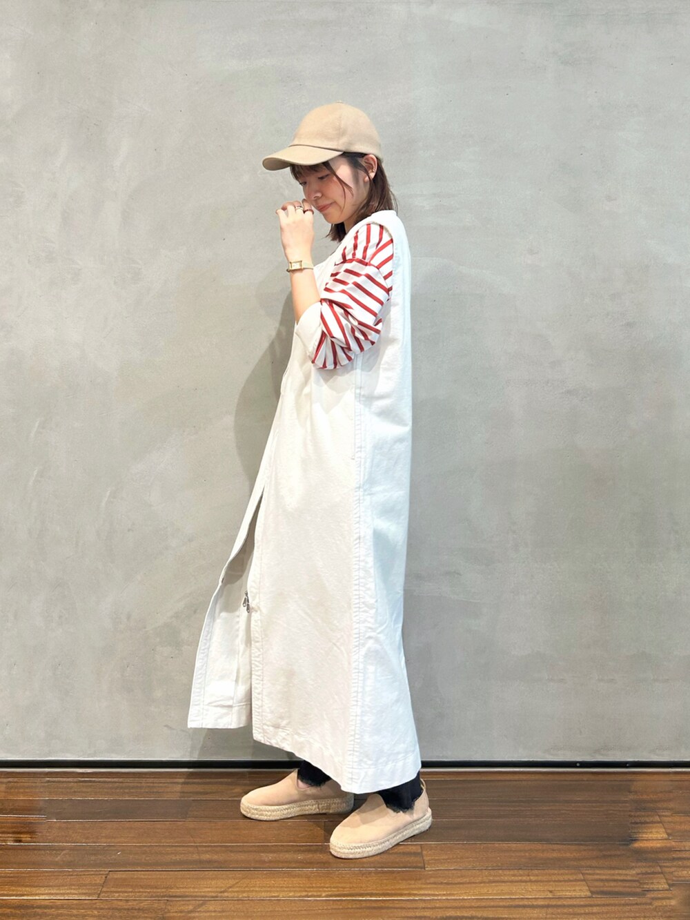 レッド系のTシャツ/カットソー、ホワイト系のワンピース、ブラック系のデニムパンツを着用したレディースの秋コーディネートの2枚目の写真