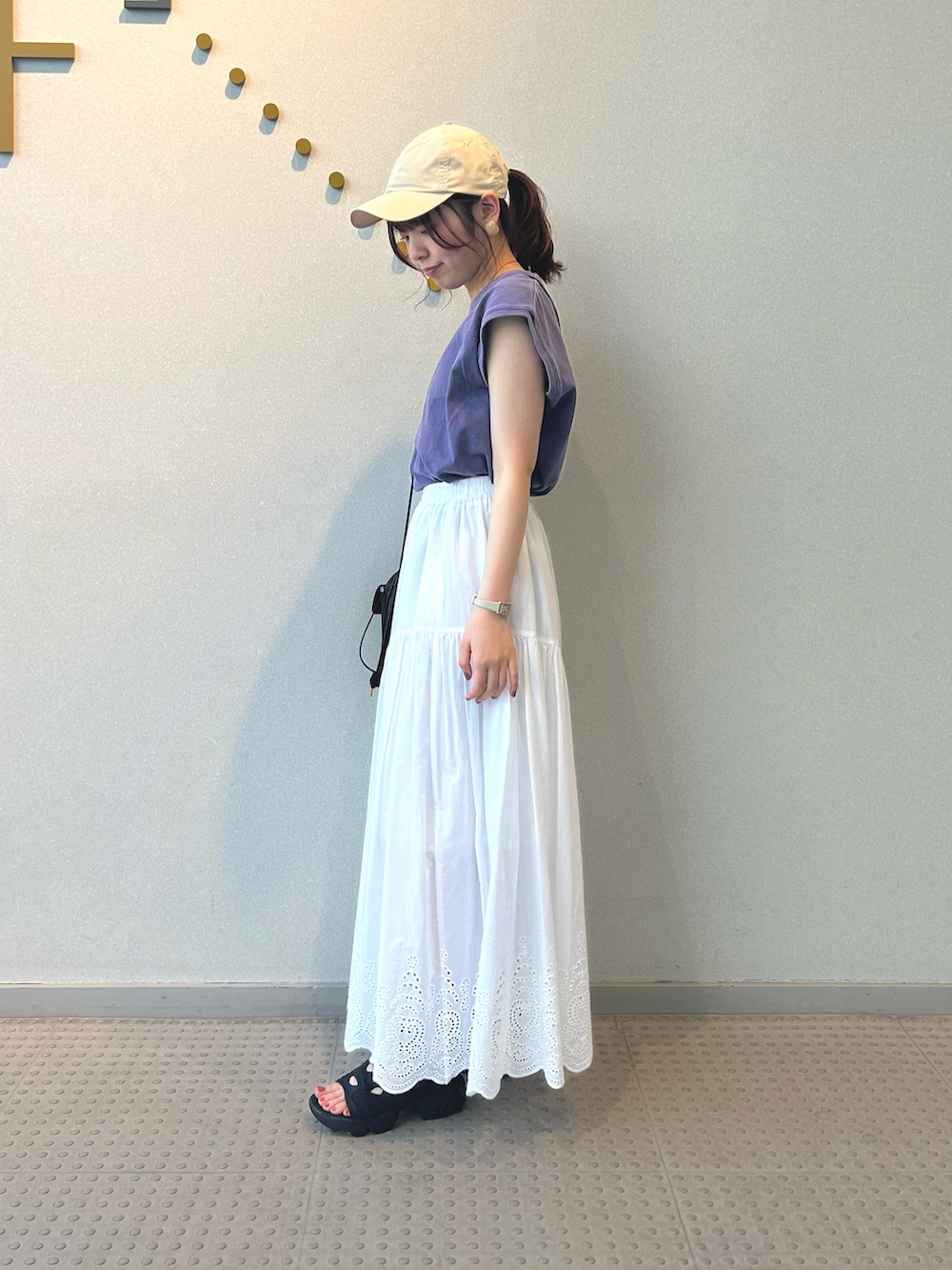 パープル系のTシャツ/カットソー、ブラック系のショルダーバッグ、ホワイト系のスカートを着用したレディースの夏コーディネートの3枚目の写真
