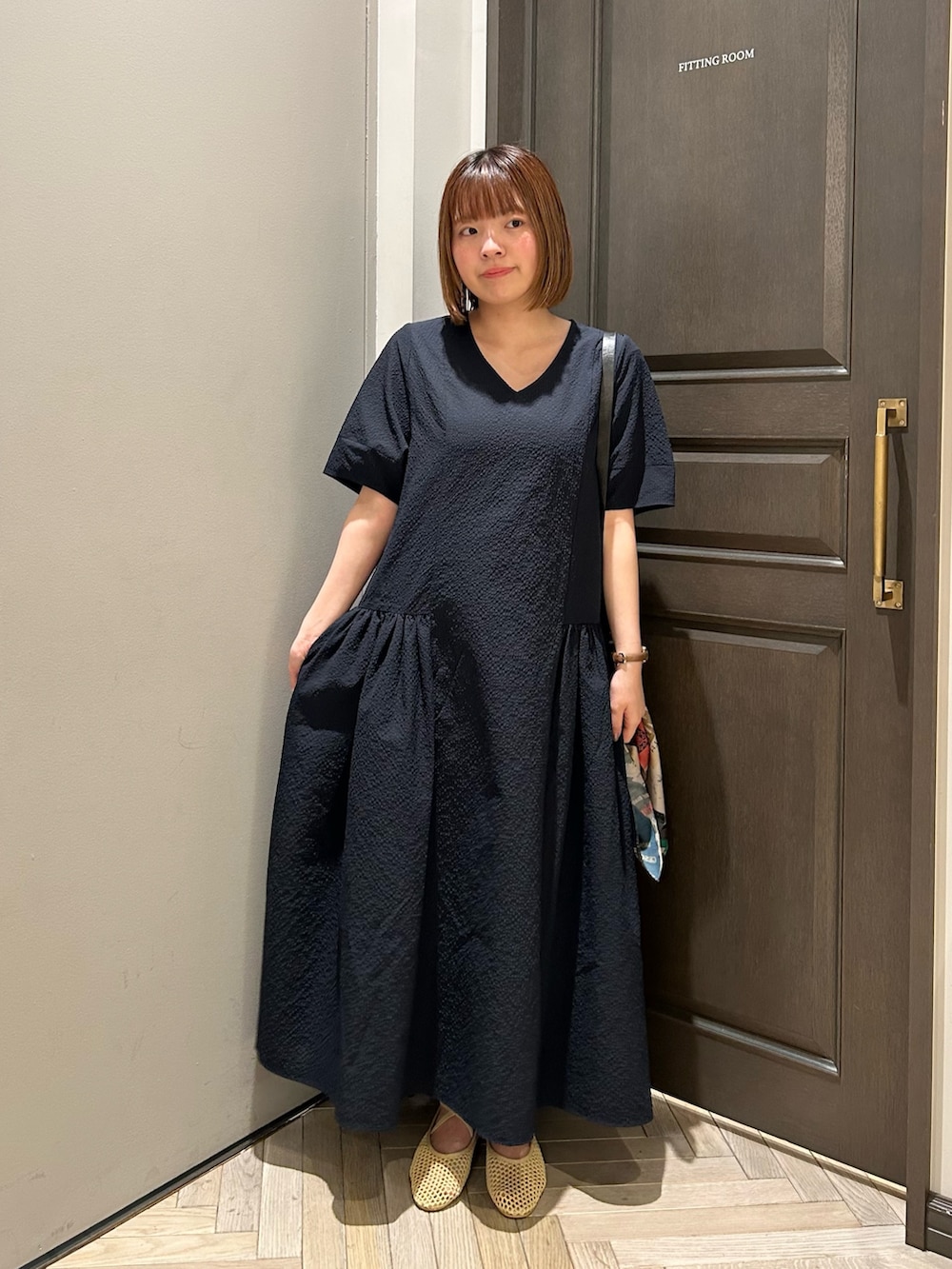 ベージュ系のバレエシューズ、ブルー系のワンピース、ベージュ系のショルダーバッグを着用したレディースの夏コーディネートの2枚目の写真
