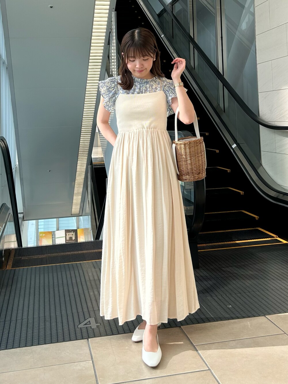 ベージュ系のワンピース、ブルー系のシャツ/ブラウス、ホワイト系のかごバッグを着用したレディースの夏コーディネートの2枚目の写真
