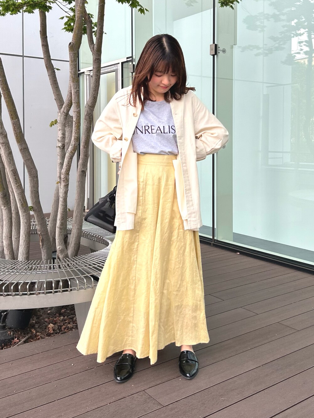 グレー系のTシャツ/カットソー、ベージュ系のシャツ/ブラウス、イエロー系のスカートを着用したレディースの春コーディネートの2枚目の写真