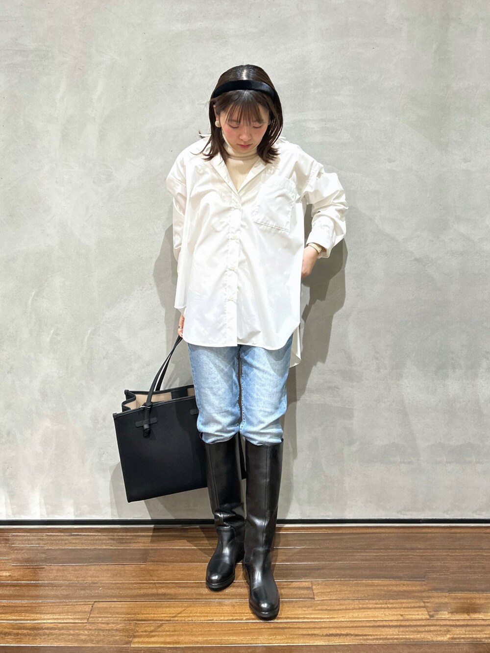 ホワイト系のシャツ/ブラウス、ホワイト系のニット/セーター、ブルー系のデニムパンツを着用したレディースの冬コーディネートの2枚目の写真