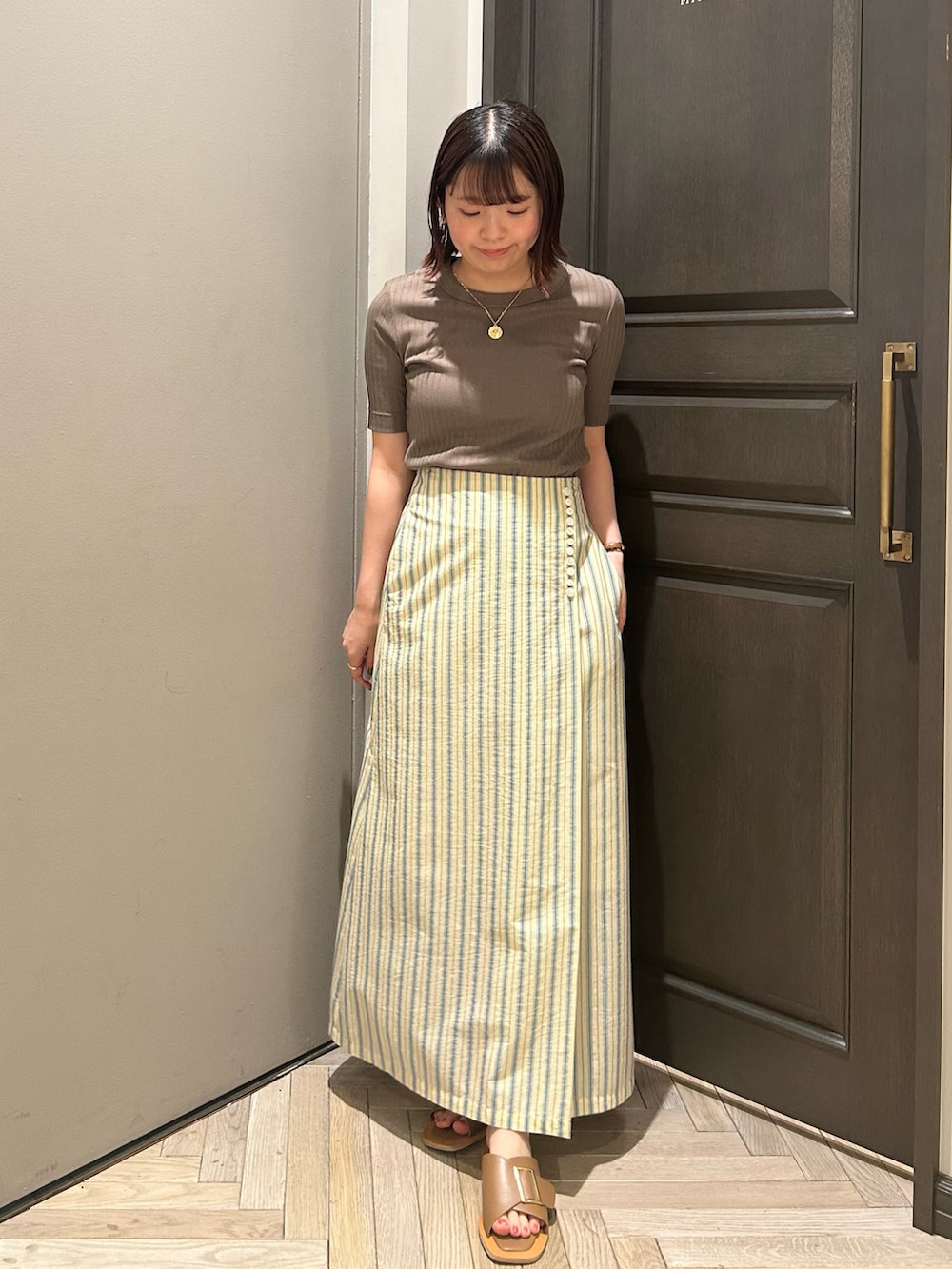 グリーン系のTシャツ/カットソー、イエロー系のスカート、ベージュ系のテーラードジャケットを着用したレディースの秋コーディネートの2枚目の写真