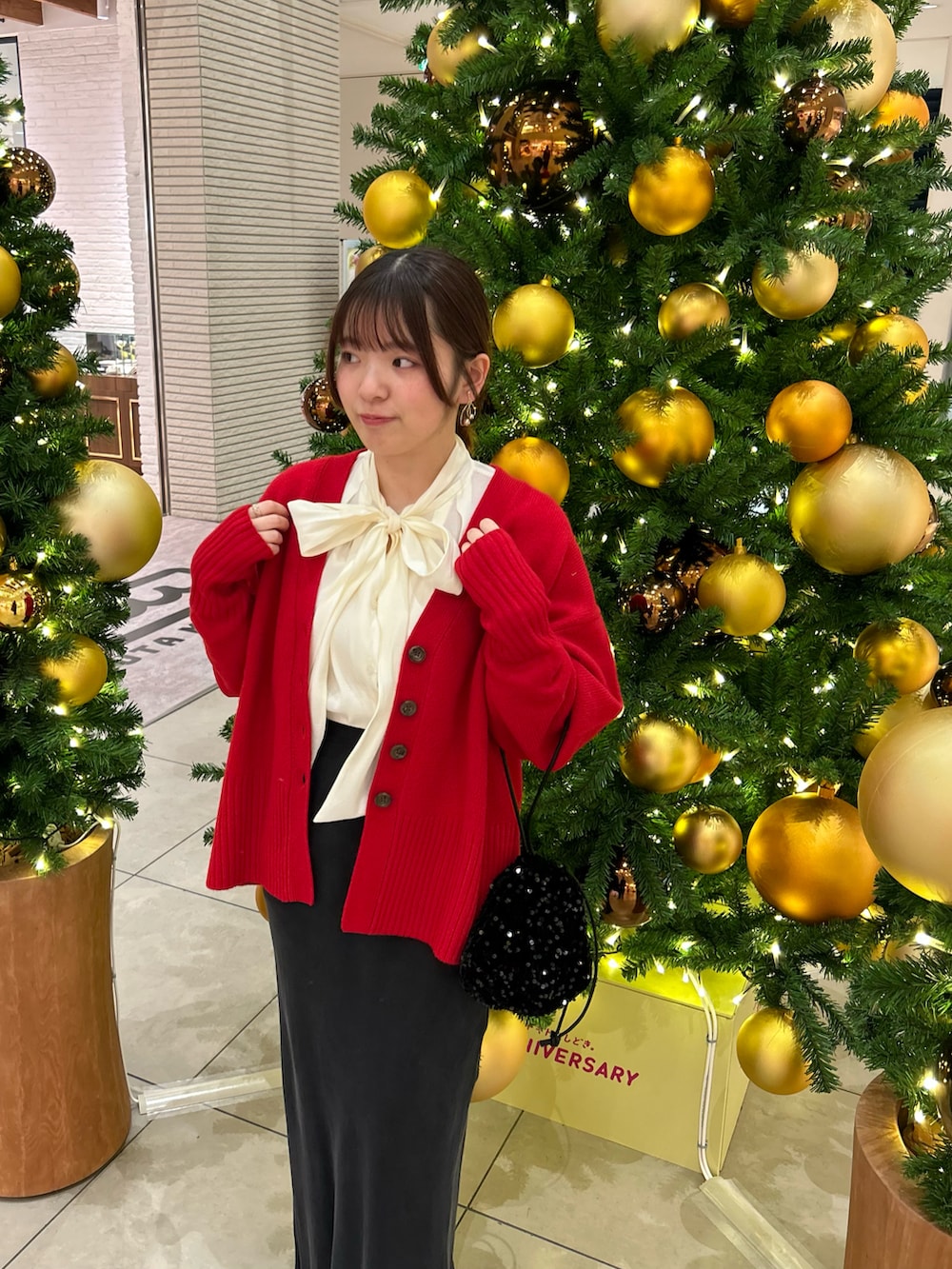 ホワイト系のシャツ/ブラウス、レッド系のカーディガン/ボレロ、ブラック系のスカートを着用したレディースの冬コーディネートの2枚目の写真