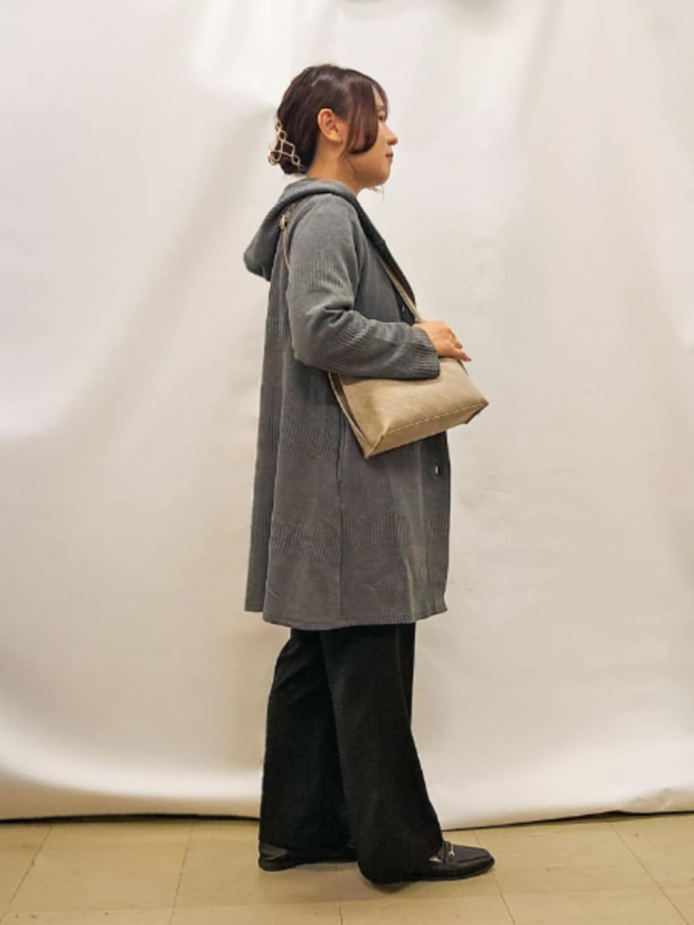 グレー系のカーディガン/ボレロ、ブラック系のニット/セーター、グレー系のショルダーバッグを着用したレディースの秋コーディネートの2枚目の写真