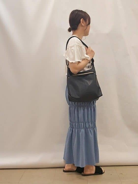 ホワイト系のTシャツ/カットソー、ブルー系のスカート、ブラック系のショルダーバッグを着用したレディースの夏コーディネートの2枚目の写真