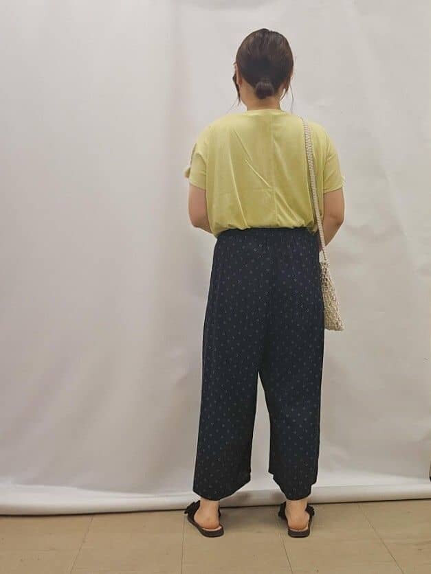イエロー系のTシャツ/カットソー、ブルー系のその他パンツ、ホワイト系のショルダーバッグを着用したレディースの夏コーディネートの3枚目の写真