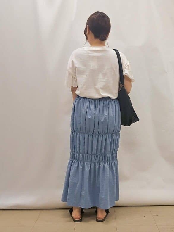ホワイト系のTシャツ/カットソー、ブルー系のスカート、ブラック系のショルダーバッグを着用したレディースの夏コーディネートの3枚目の写真