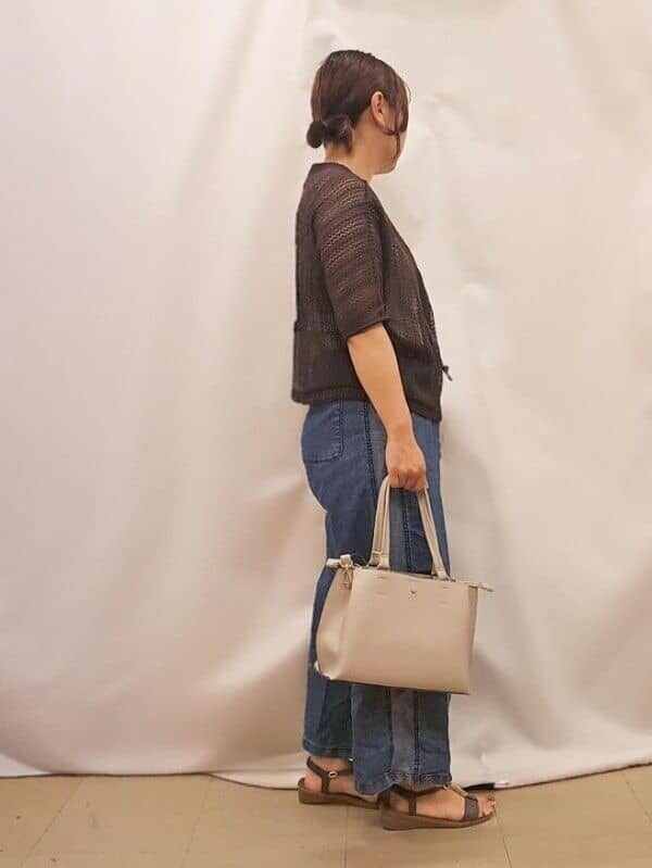 ブラウン系のブルゾン、ゴールド系のタンクトップ、ブルー系のデニムパンツを着用したレディースの夏コーディネートの2枚目の写真