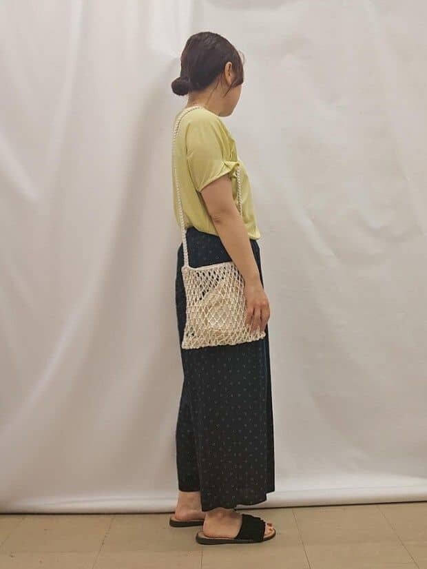 イエロー系のTシャツ/カットソー、ブルー系のその他パンツ、ホワイト系のショルダーバッグを着用したレディースの夏コーディネートの2枚目の写真