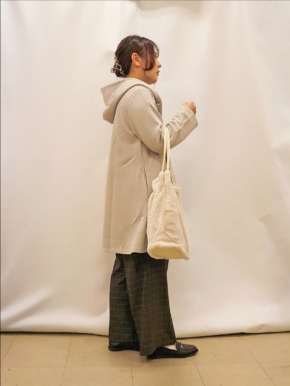 ベージュ系のカーディガン/ボレロ、ブラック系のTシャツ/カットソー、グレー系のその他パンツを着用したレディースの秋コーディネートの2枚目の写真