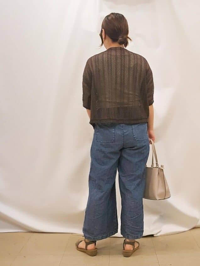 ブラウン系のブルゾン、ゴールド系のタンクトップ、ブルー系のデニムパンツを着用したレディースの夏コーディネートの3枚目の写真