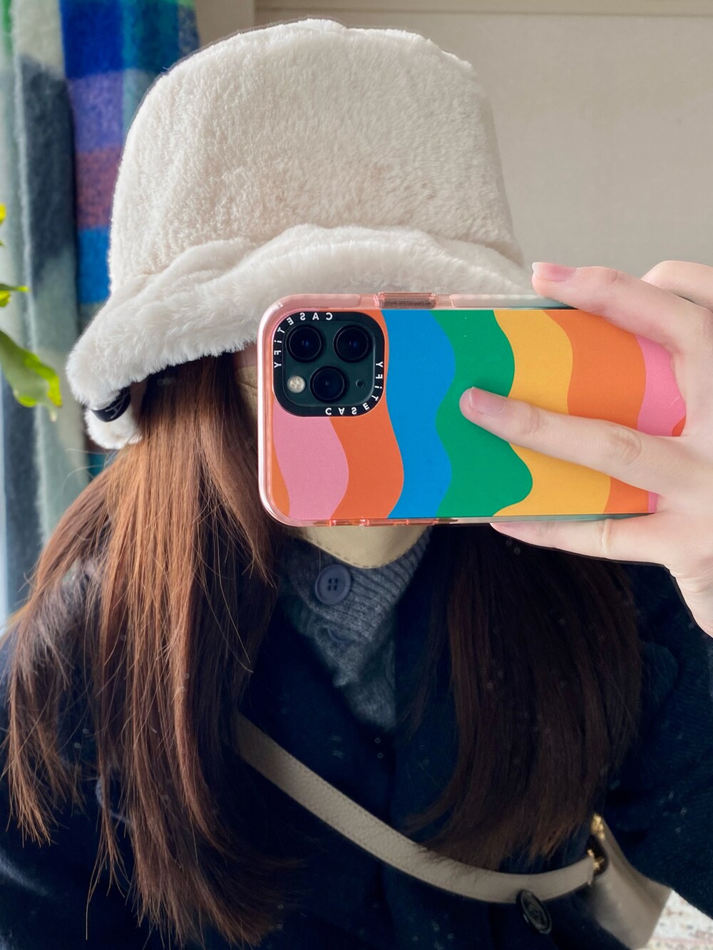 ブルー系のデニムパンツ、グリーン系のスニーカーを着用したレディースの冬コーディネートの2枚目の写真