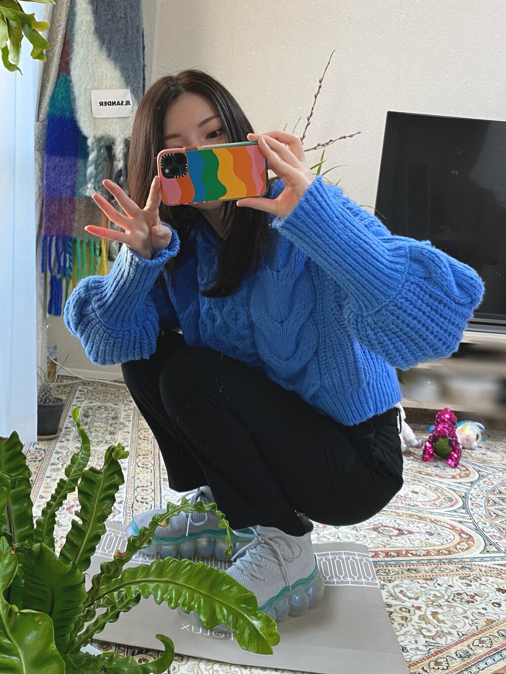 ブルー系のニット/セーター、ブラック系のパンツ、グリーン系のスニーカーを着用したレディースの冬コーディネートの2枚目の写真
