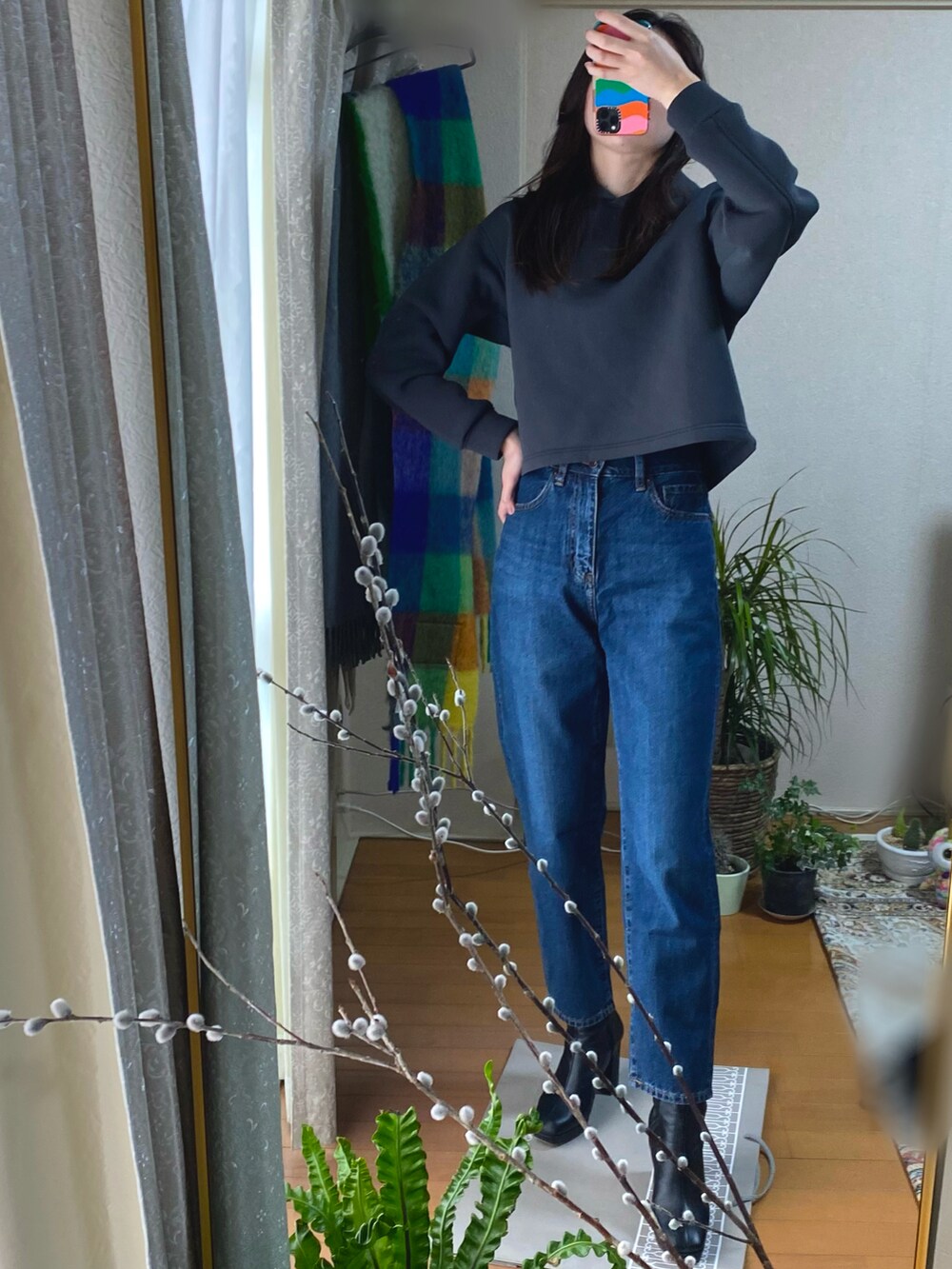 グレー系のパーカー、ブルー系のデニムパンツを着用したレディースの冬コーディネートの2枚目の写真