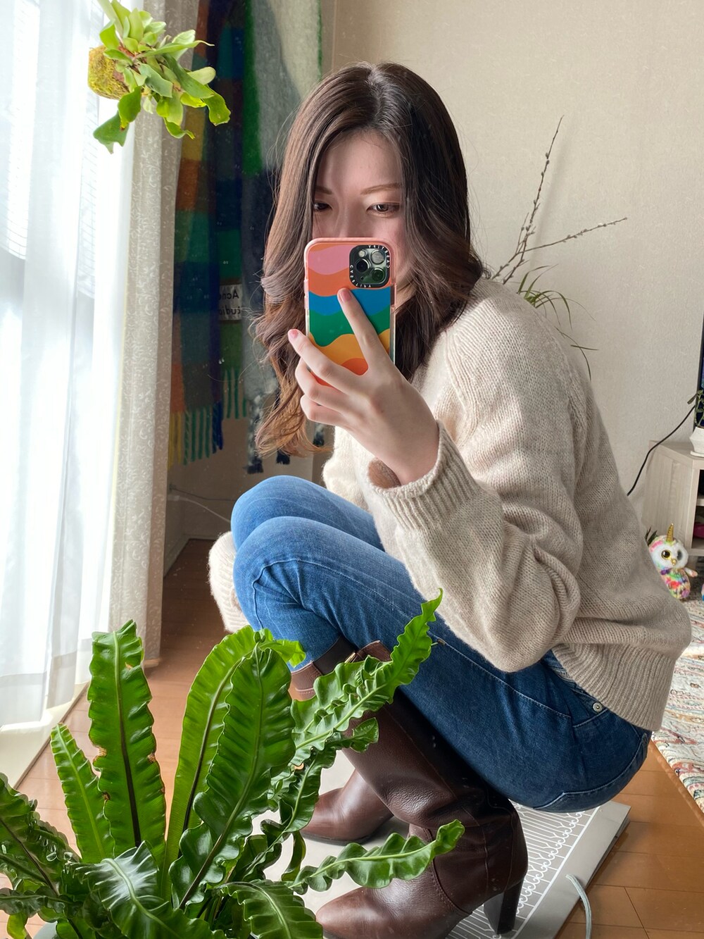 ベージュ系のニット/セーター、ブルー系のデニムパンツ、ブラウン系のブーツを着用したレディースの冬コーディネートの2枚目の写真