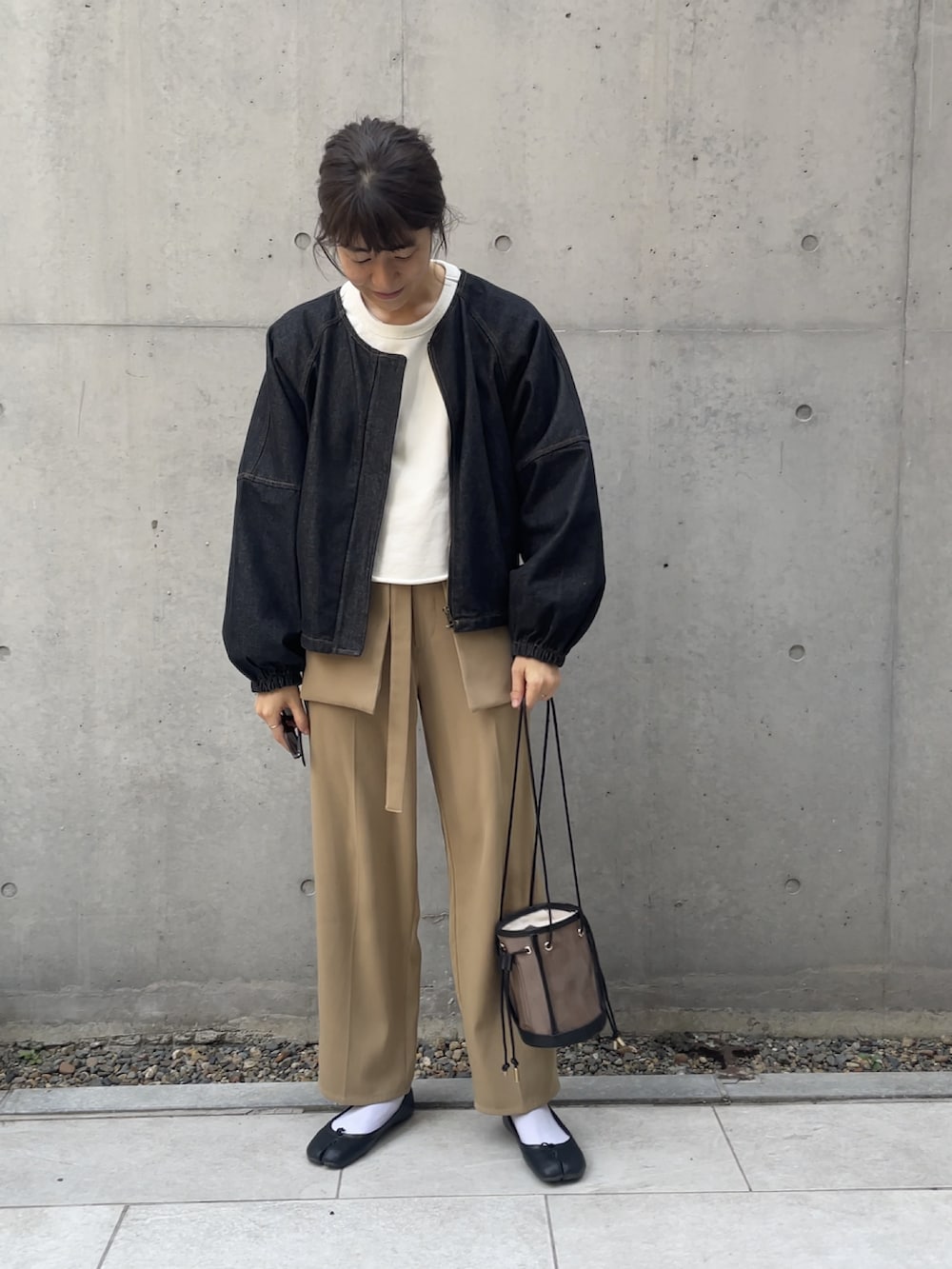 ブラック系のトートバッグ、ベージュ系のその他パンツ、ブラック系のデニムジャケットを着用したレディースの冬コーディネートの3枚目の写真