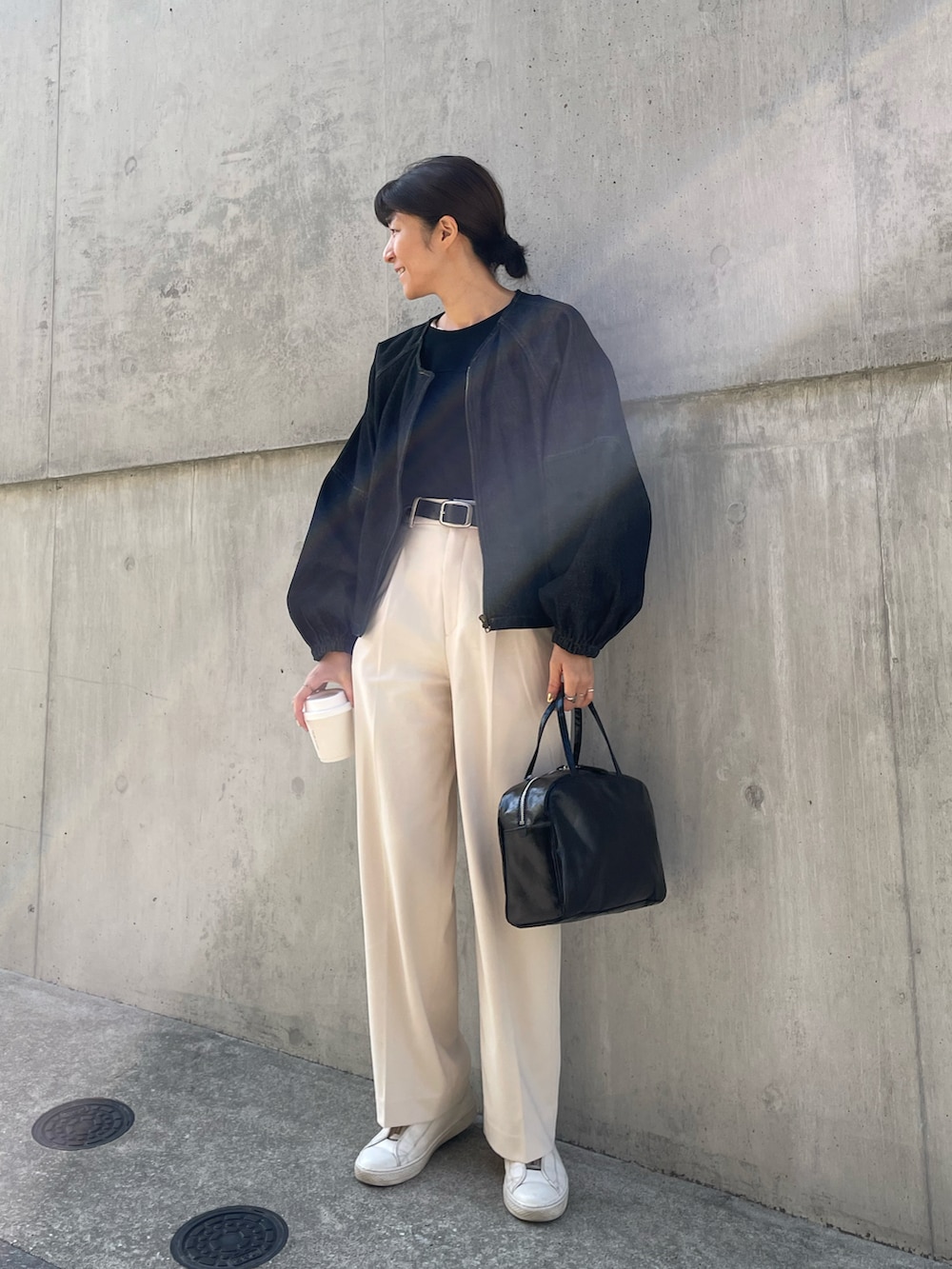 ブラック系のボストンバッグ、ホワイト系のパンツ、ブラック系のTシャツ/カットソーを着用したレディースの春コーディネートの2枚目の写真