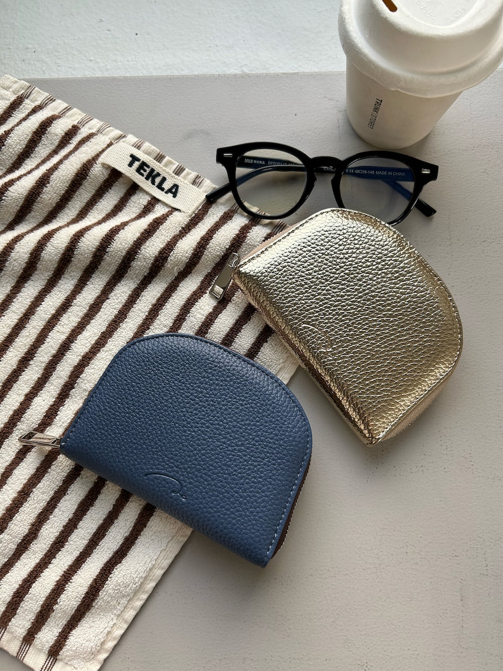 ブルー系のポーチ、シルバー系のネックレスを着用したレディースの秋コーディネートの3枚目の写真