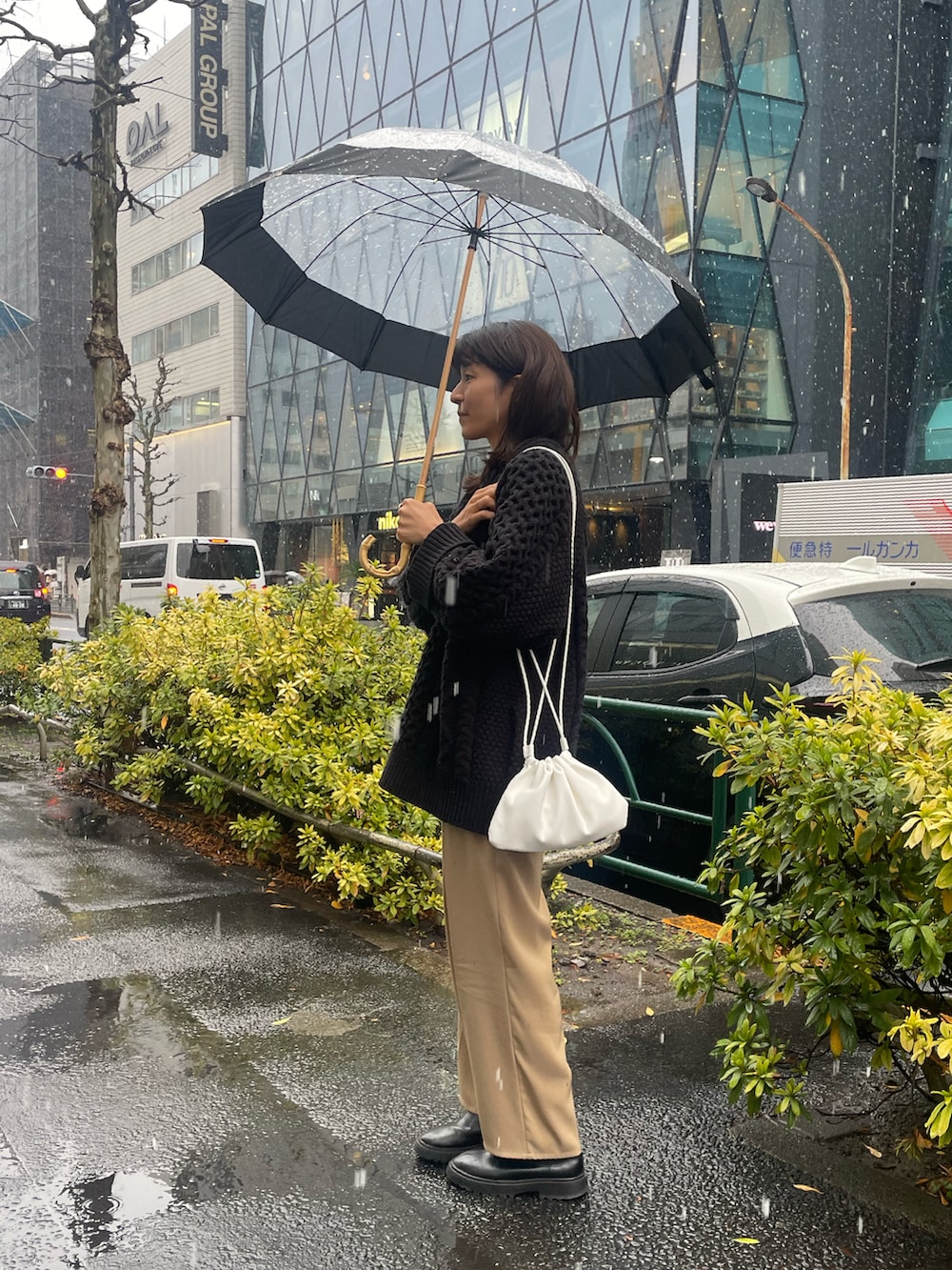 ホワイト系のショルダーバッグ、ブラック系のニット/セーター、ベージュ系のその他パンツを着用したレディースの冬コーディネートの3枚目の写真