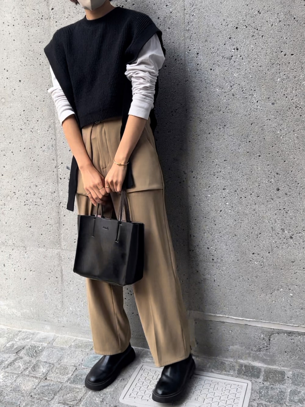 ブラック系のトートバッグ、ブラック系のベスト、ベージュ系のその他パンツを着用したレディースの秋コーディネートの2枚目の写真