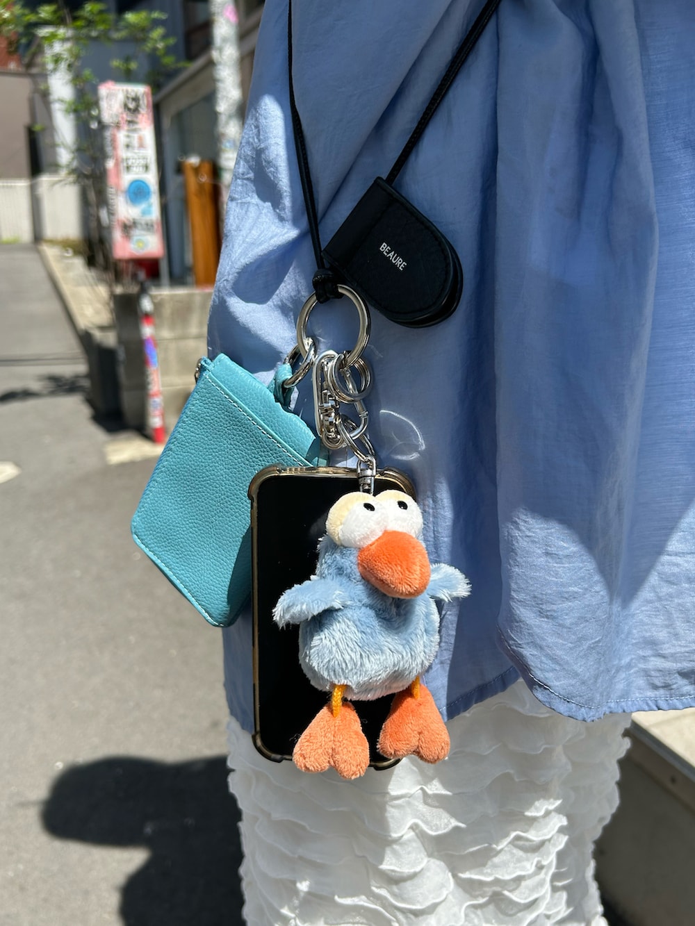 ホワイト系のサンダル、ホワイト系のスカート、ブルー系のシャツ/ブラウスを着用したレディースの春コーディネートの2枚目の写真