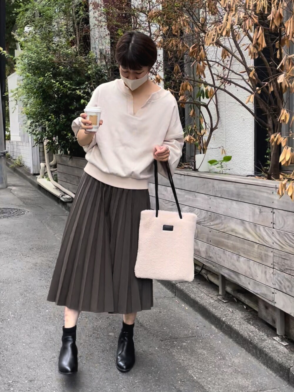 ホワイト系のトートバッグ、グリーン系のスカート、ベージュ系のスウェットを着用したレディースの夏コーディネートの2枚目の写真